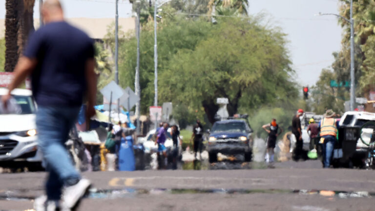 July 2023 was the hottest month recorded to date A photo of a busy street with people walking around and cars on the road. Heat haze can be seen on the road.