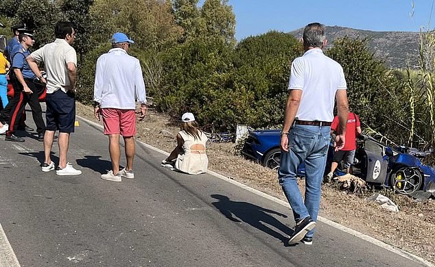 Moment supercar convoy jumped red lights and breached traffic regulations before fatal crash that saw couple burn to death – as billionaire Lamborghini driver under police investigation returns to India Gayatri Joshi is pictured on the side of the road, with reports claiming she was crying as she surveyed the wreckage of their car in the aftermath of the crash. Her husband Vikas Oberoi is believed to be the man watching on with hands on hips according to Indian media outlet NDTV