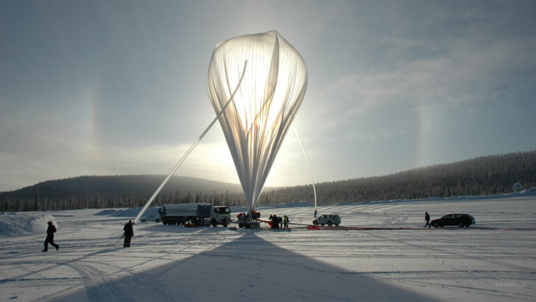 A new UN report lays out an ethical framework for climate engineering An upright weather balloon sits on a snowy landscape, surrounded by people and vehicles