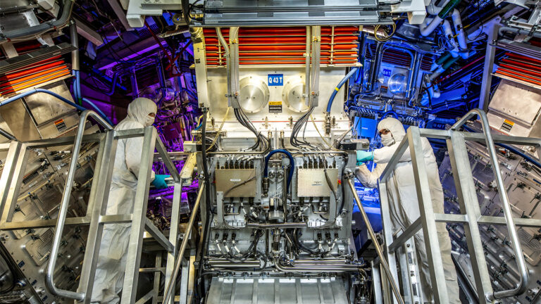 Here’s how scientists reached nuclear fusion ‘ignition’ for the first time Two workers stand in front of equipment at the National Ignition Facility.