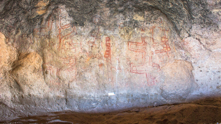 These South American cave paintings reveal a surprisingly old tradition A cave wall in Patagonia is covered with pictures of several large figures and shapes made with some kind of red drawing material. Some art in this cave dates back to as early as 8,200 years ago.