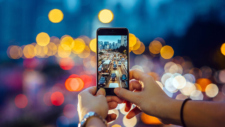 Living lenses? Glass-coated microbes might take better photos a photo of a cell phone taking a photo of a highway overpass (looking down at traffic) at dusk. The image on the phone is in focus, but the surroundings are out of focus.