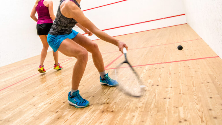 No player can return this killer shot. Physics explains how it works A person prepares to hit a squash ball with a racket.